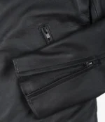 Close-up of a black leather jacket's sleeve with silver zippers. The texture appears smooth and sleek, suggesting a stylish, modern design.