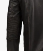 Close-up of a dark brown leather jacket sleeve featuring ribbed padding on the elbow area, with visible stitching. The material appears rugged and durable.