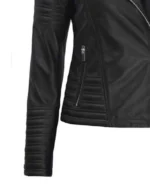 Close-up of a black leather jacket with quilted sleeves and side zippers, showcasing its sleek texture and modern design.