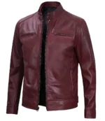A sleek maroon leather jacket with a stand-up collar, zippered front, and pockets. The rich color and smooth texture convey a stylish, modern vibe.
