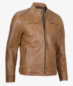 Tan leather jacket with a sleek design, featuring a front zipper, two horizontal chest pockets, and a stand collar. The tone is stylish and modern.
