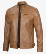 A tan leather jacket with a stand collar, front zipper, and two chest pockets. The leather has a smooth finish, conveying a classic, stylish look.