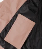 Close-up of a light pink leather jacket interior showcasing a rectangular pink pocket against a smooth black lining, emphasizing contrast and texture.