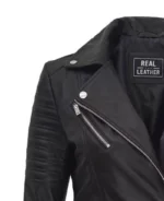 Close-up of a black leather jacket featuring a diagonal silver zipper and quilted shoulder pads. Inside label reads Real Leather. Rugged and stylish.