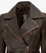 Close-up of a dark brown leather jacket with a wide lapel and silver zippers. The texture is smooth, conveying a stylish and classic look.