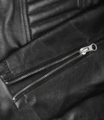 Close-up of a black leather jacket with visible silver zipper. The texture is smooth, conveying a sleek and stylish appearance.