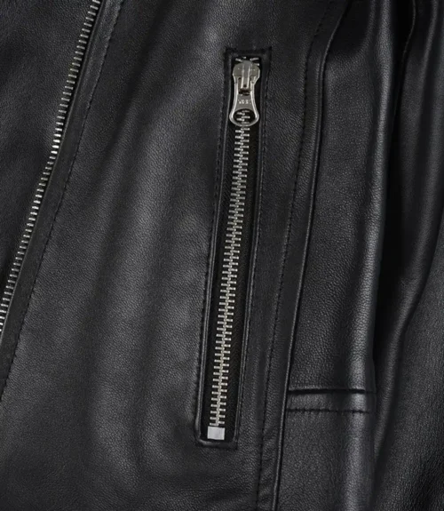 Close-up of a black leather jacket featuring a vertical silver zipper. The texture appears smooth, exuding a sleek, classic, and edgy style.