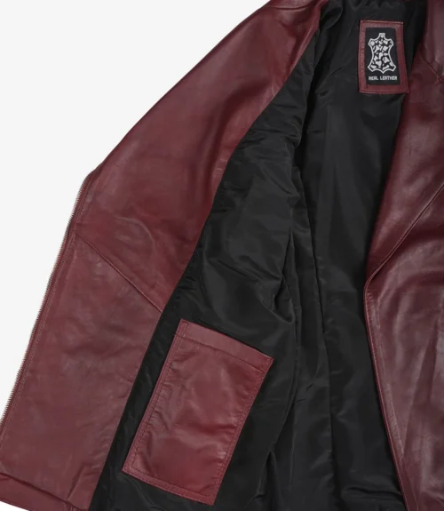 Open burgundy leather jacket displayed on a white background. Features a black lining and inside pocket, with a visible Real Leather label, evoking elegance.