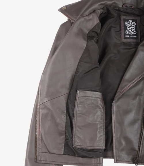 Brown leather jacket with inner black lining and a "Real Leather" label. The jacket has bronze snap buttons, creating a classic and rugged feel.