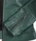 Close-up of a green leather jacket sleeve with a zippered cuff and ribbed detailing. Sleek and stylish, conveying a modern, edgy vibe.