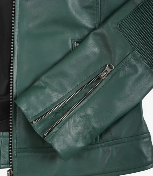 Close-up of a green leather jacket sleeve with a zippered cuff and ribbed detailing. Sleek and stylish, conveying a modern, edgy vibe.