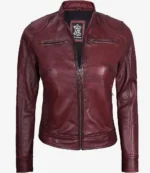 Deep burgundy leather jacket with a front zipper, collarless neck, and zippered chest pockets. The texture is smooth, conveying a sleek, stylish look.