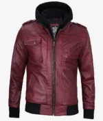 A maroon leather jacket with black ribbed cuffs and hem, featuring zippered and buttoned pockets. The jacket has a detachable black hood, creating a stylish, edgy look.