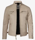 Beige leather jacket on a white background, featuring a high collar, quilted shoulders, two chest zips, and a sleek black inner lining. Stylish and modern.
