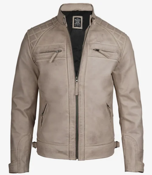 Beige leather jacket with a standing collar and front zipper, featuring quilted shoulders and zippered chest pockets. The design is sleek and modern.