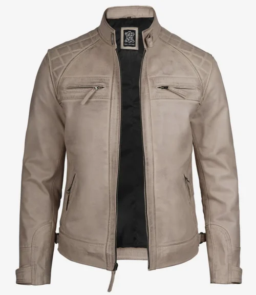 Beige leather jacket with a quilted pattern on shoulders, zippered chest pockets, and a sleek design. Black inner lining adds contrast.