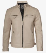 Tan leather jacket with a stand collar and quilted shoulders. Features four zippered pockets and a front closure, exuding a sleek, stylish vibe.