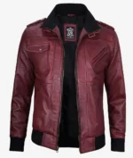 Maroon leather jacket with a vintage motorcycle style. Features include zippered pockets, black ribbed cuffs, collar, and waistband, exuding a bold, edgy tone.