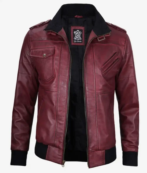 Maroon leather jacket with a vintage motorcycle style. Features include zippered pockets, black ribbed cuffs, collar, and waistband, exuding a bold, edgy tone.