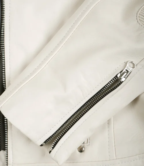 Close-up of a white leather jacket showcasing sleek stitching, a silver zipper partially open, and a metal snap button, conveying a modern, stylish look.