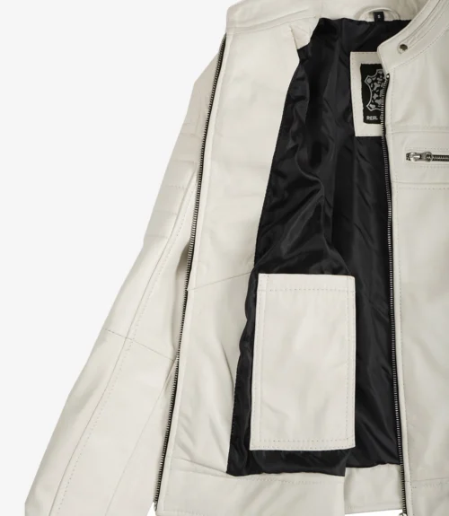 White leather jacket partially open, revealing a black interior lining and a label. The design features a zippered chest pocket and an inner pocket.