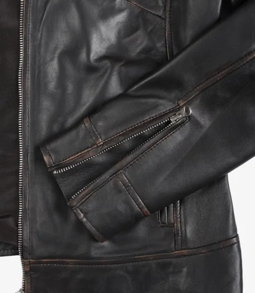 Close-up of a black leather jacket focusing on the sleeve, decorated with a prominent zipper. The material appears shiny, conveying a rugged, stylish tone.
