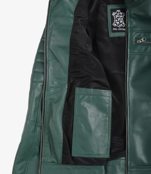 Open green leather jacket showing interior. Features black lining, a label reading Real Leather, and a visible inner pocket. Stylish and modern.