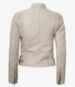 Alt text: Back view of a beige leather jacket with a high collar and adjustable waist tabs. It features long sleeves with zippers, creating a sleek, modern look.