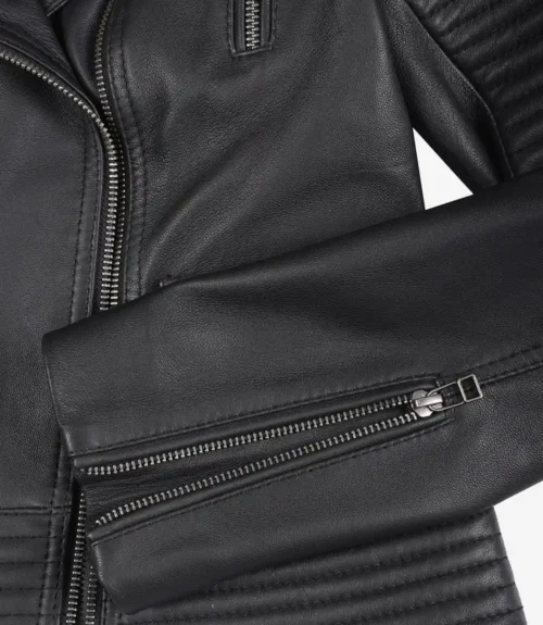 Close-up of a black leather jacket featuring silver zippers and quilted stitching. The sleek design conveys a modern and edgy style.