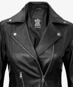 Close-up of a black leather biker jacket with silver zippers and buttons. The label inside reads Real Leather. The style is sleek and edgy.