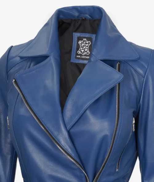 Close-up of a blue leather jacket with a large collar and silver zippers. A tag inside labeled Real Leather is visible. The tone is sleek and stylish.