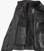 Open black leather jacket showing the interior lining. Features several pockets and visible zippers. The label reads Real Leather. Sleek, modern design.