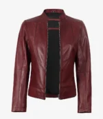 A maroon leather jacket with a sleek, minimalist design, featuring a zippered front and a high collar. The jacket conveys a chic and stylish tone.