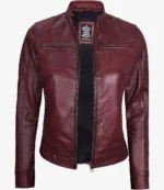 Burgundy women's leather jacket with a front zipper, high collar, and minimalist style. The jacket exudes a sleek and modern feel.
