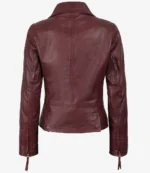 Burgundy leather jacket shown from the back, featuring a sleek design with long sleeves, zippered cuffs, and a fitted waist. The tone is stylish and edgy.