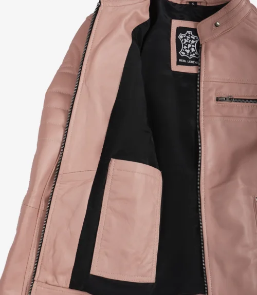 Open pink leather jacket with quilted shoulders and silver zipper detail. The inner lining is black with a "Real Leather" label visible, conveying a stylish, modern vibe.