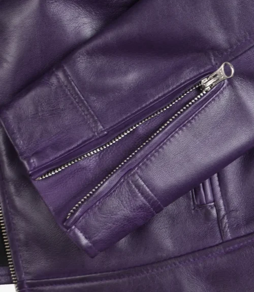 Close-up of a purple leather jacket focusing on the sleeve and silver zipper. The texture is smooth and shiny, conveying a stylish, modern feel.