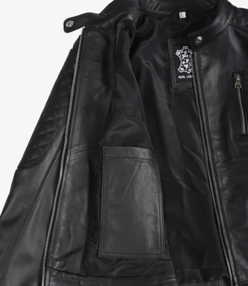 Open black leather jacket with visible interior showing quilted padding on the sleeve, zipper detail, and fabric label indicating "Real Leather."