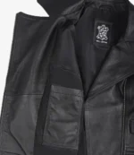 Open black leather jacket laid flat, revealing inner lining with a pocket and a Real Leather label. The texture appears smooth and sleek.