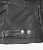 Close-up of a black leather jacket corner with visible stitching and metallic snap buttons, conveying a rugged and stylish tone.