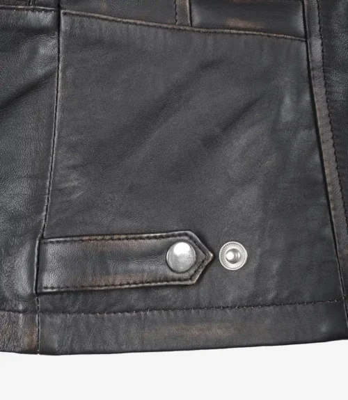 Close-up of a black leather jacket corner with visible stitching and metallic snap buttons, conveying a rugged and stylish tone.