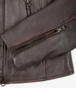 Close-up of a brown leather jacket sleeve with a visible metal zipper detail. The texture appears smooth, conveying a sleek and stylish design.