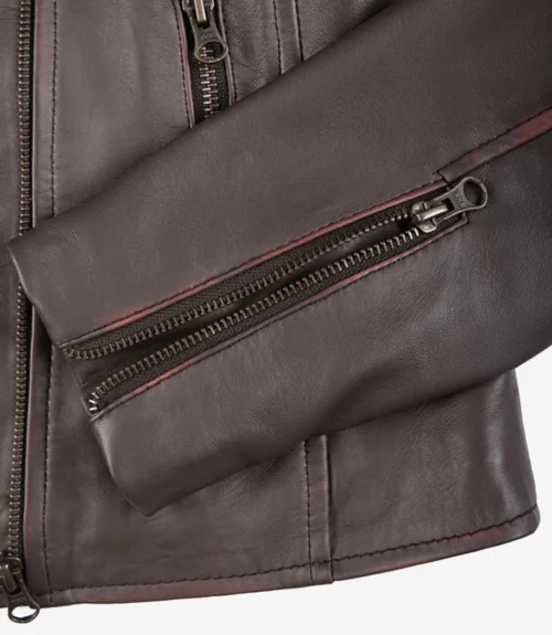 Close-up of a brown leather jacket sleeve with a visible metal zipper detail. The texture appears smooth, conveying a sleek and stylish design.