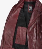 Maroon leather jacket with a black lining is open to reveal an inner pocket and a Real Leather tag. The tone is stylish and rugged.