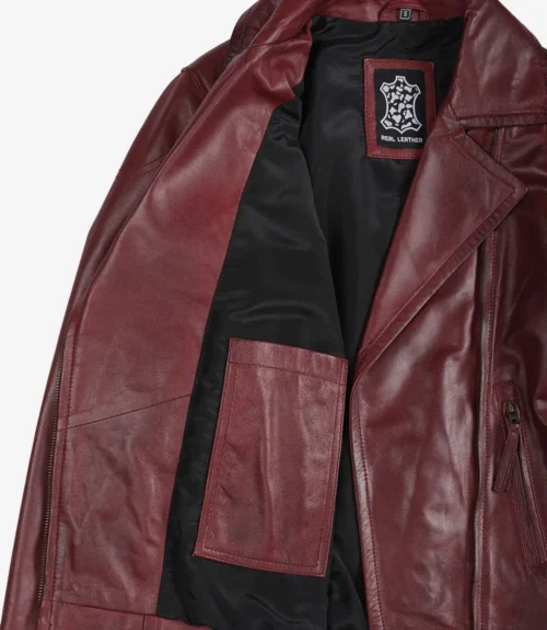Maroon leather jacket with a black lining is open to reveal an inner pocket and a Real Leather tag. The tone is stylish and rugged.