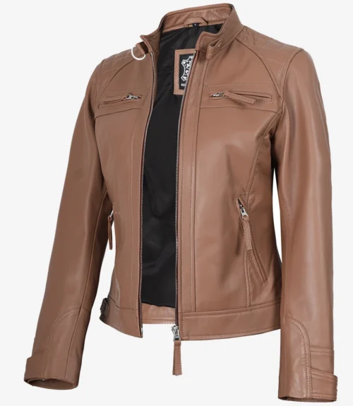 Tan leather jacket with a stand collar, front zipper slightly open revealing a black interior. It features multiple zippered pockets and sleek stitching.