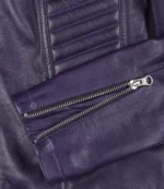 Close-up of a purple leather jacket, showcasing its texture and detailing. The image highlights a silver zipper on the sleeve, conveying a stylish, edgy tone.