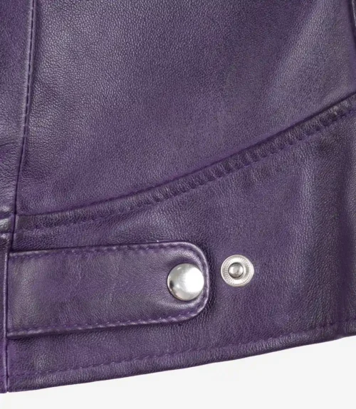 Close-up of a purple leather jacket featuring smooth texture and silver snap buttons. The stitching highlights the sleek, stylish design.
