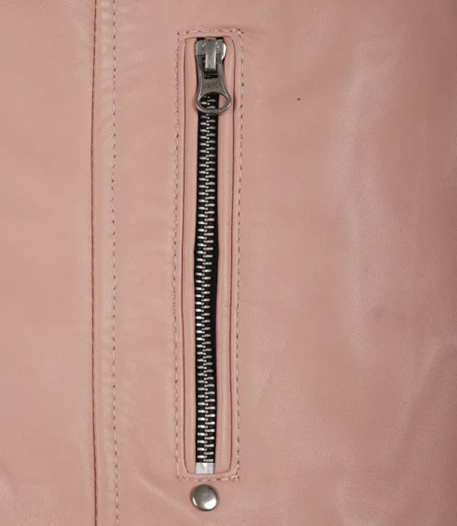 Close-up of a pink leather jacket showing a vertical silver zipper and stitching. The sleek texture and color give a stylish, modern feel.