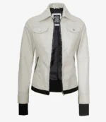 A light beige leather jacket with a high collar and prominent buttoned pockets. The jacket is open, revealing a black inner lining.